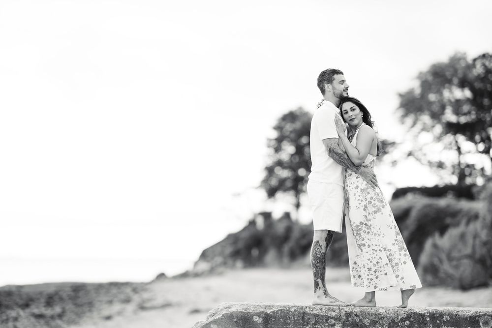 Black and white summer portrait of people playing and spinning in a field during golden hour.
