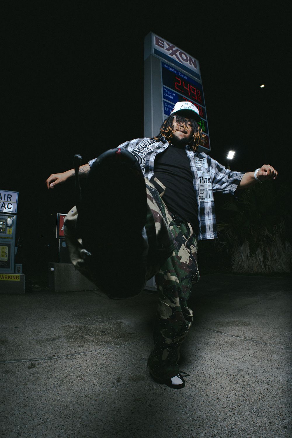 Person executing dynamic skateboard maneuvers at night under illuminated signage.