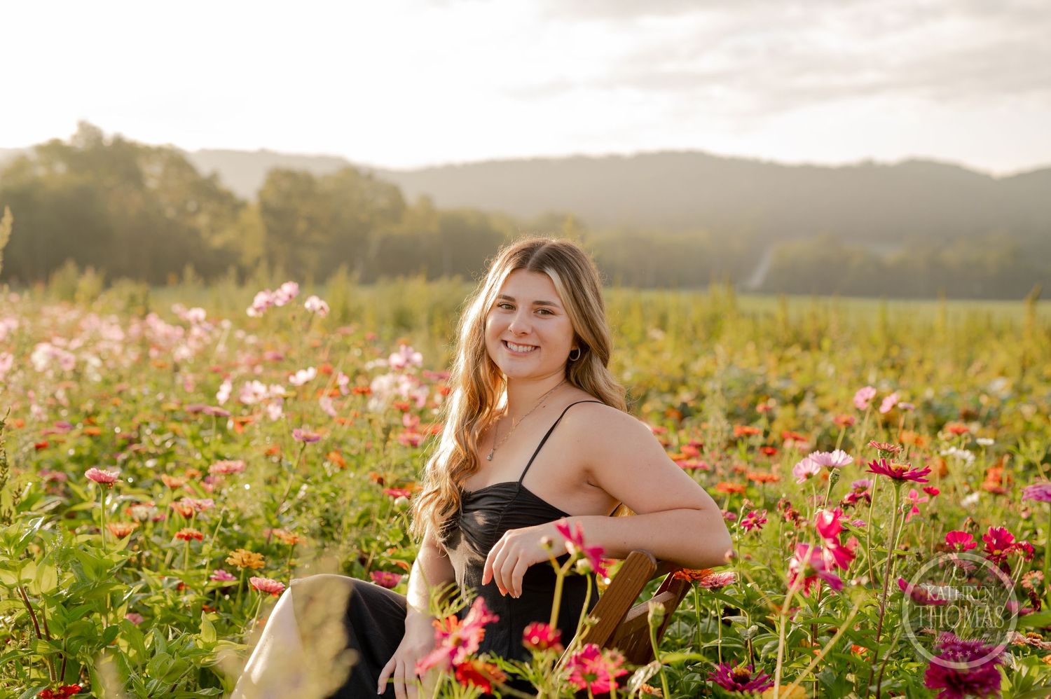 Natural outdoor photography session in a field of pink and red flowers with soft evening light.