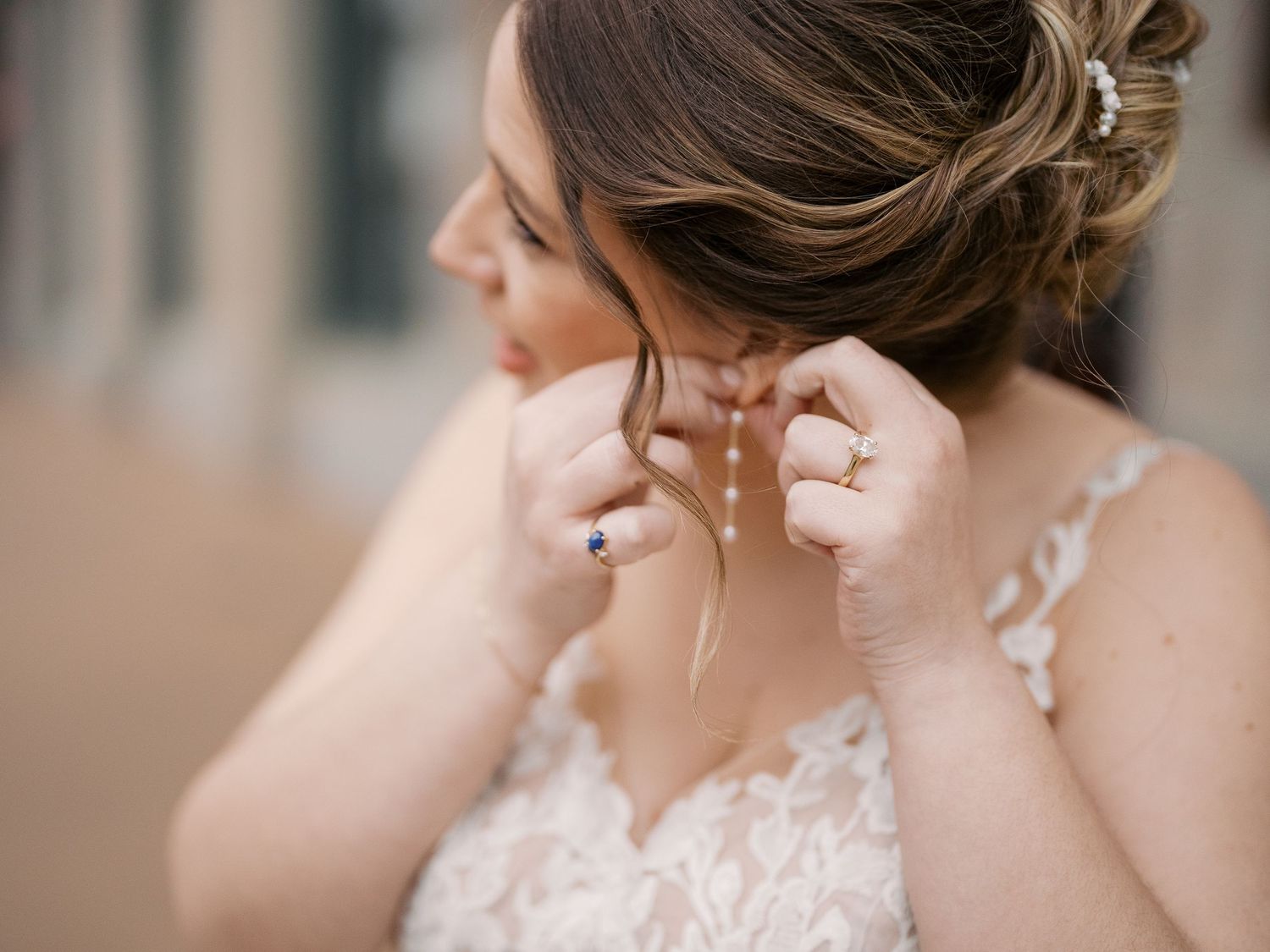 Close-up photo of wedding day jewelry and a delicate lace dress strap.