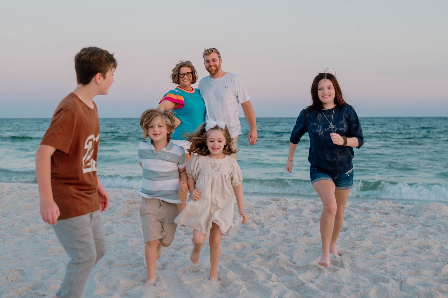 Kids running on a beach during lifestyle photography session