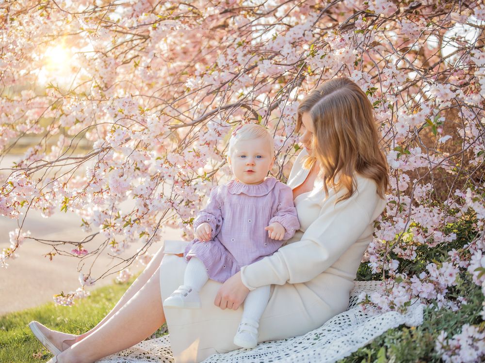 Mamma och barn vid blommande träd i kvällsljus, familjefotografering Västerås. MemoriebyM