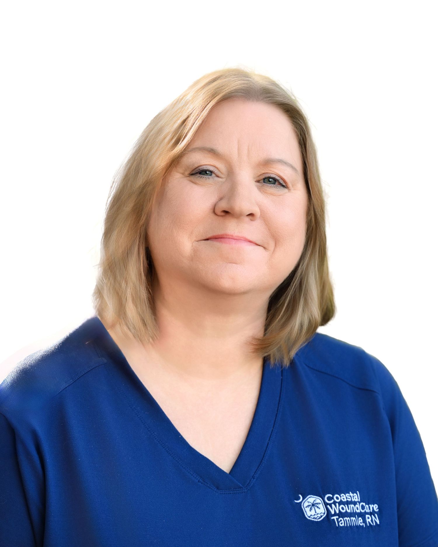 Coastal Wound Care nurse Tammie in blue scrubs poses for professional photo.