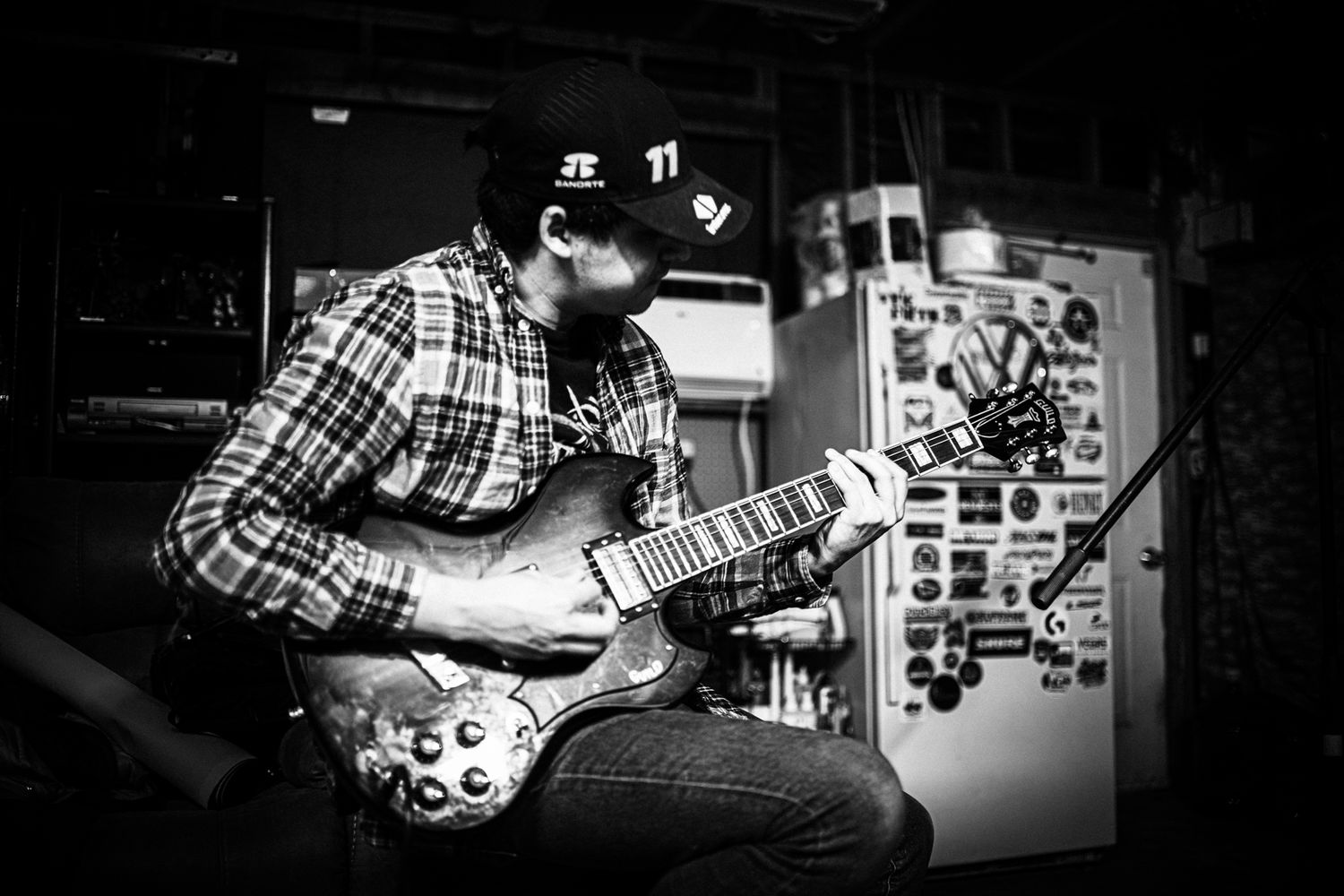 Close-up shots of hands playing guitars and musical instruments in dark lighting.
