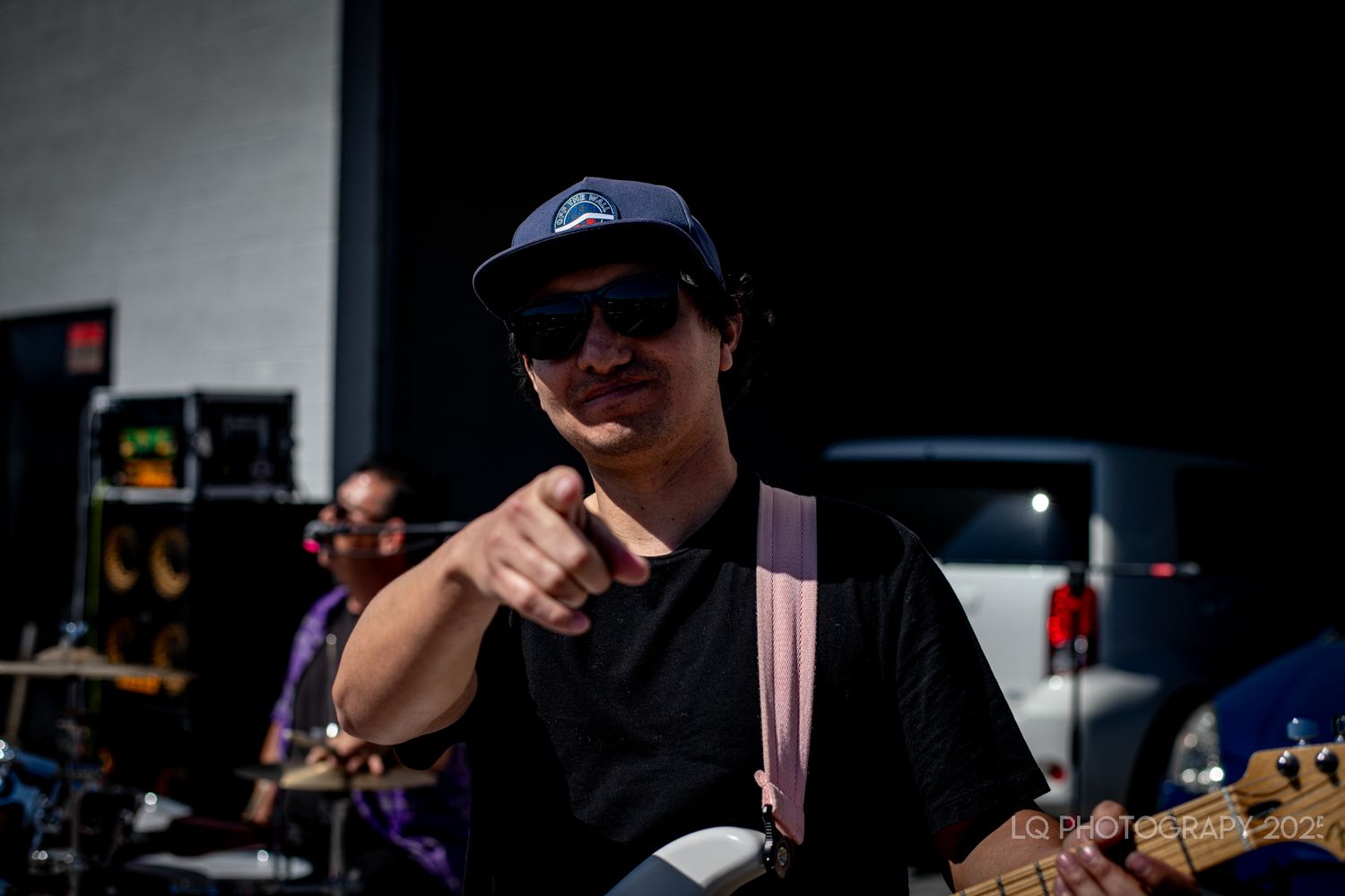 Musician giving thumbs up while performing at outdoor event.