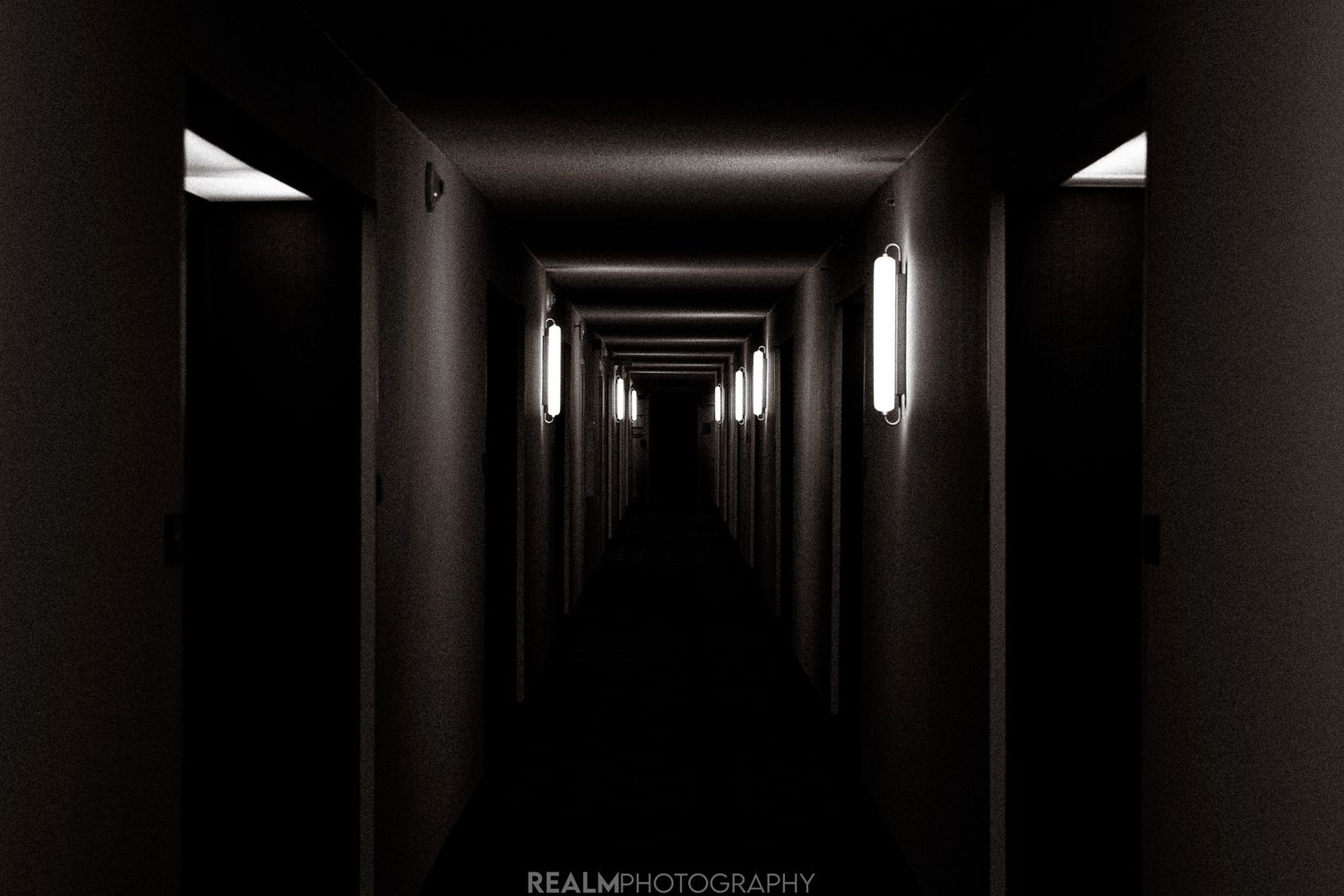 Dark corridor with dramatic lighting creates an atmospheric perspective down a hallway.