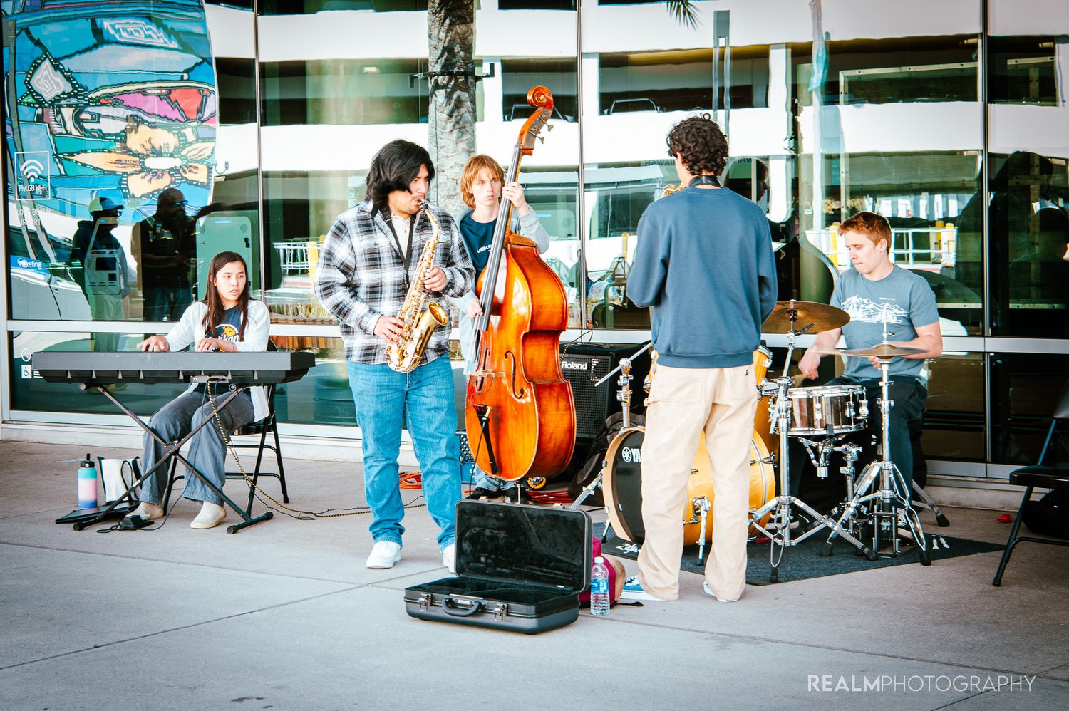 People gathered outdoors at a casual event with chairs and equipment visible.