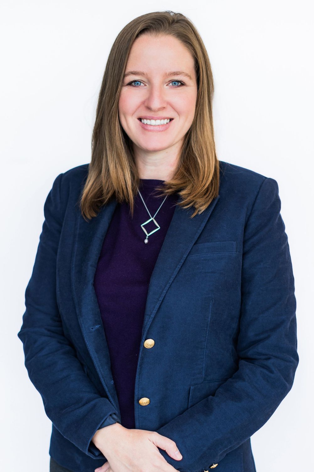 Professional headshot series showing same person in navy blazer and dark top against white background.