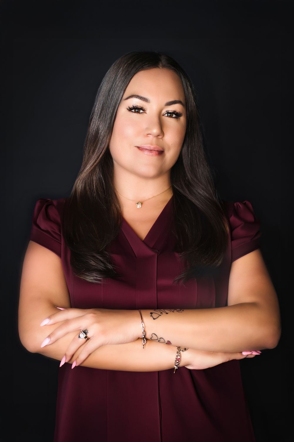 A series of professional portraits showing a person in a burgundy top against a dark background with dramatic lighting.
