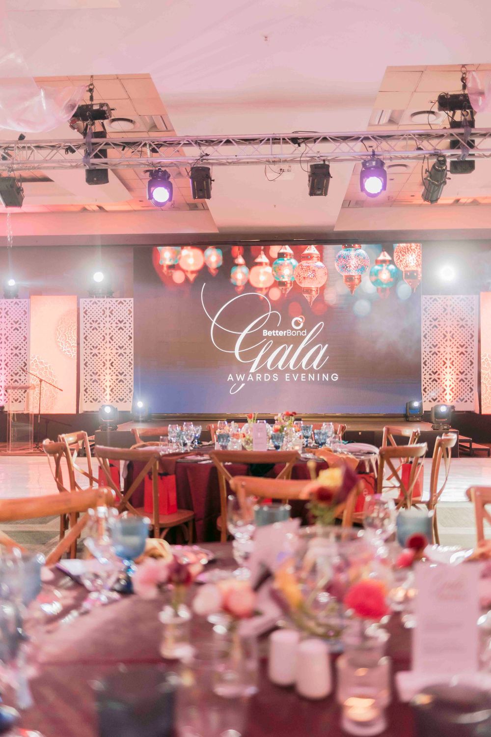 BetterBond Gala Awards Evening ballroom with elegant table settings, floral decor, and illuminated stage backdrop.