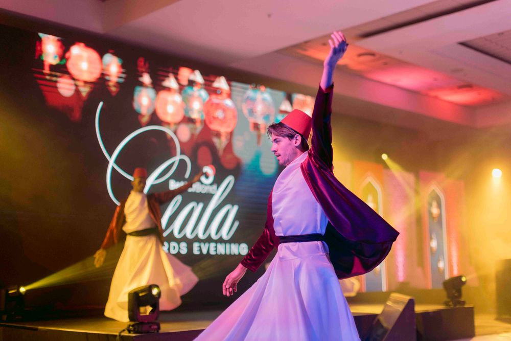 Female whirling dervish dancer in white and purple costume performing at Gala Awards Evening.