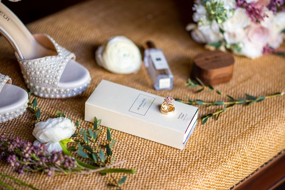 Wedding detail shot showing delicate floral arrangements and decor on a rustic burlap surface.