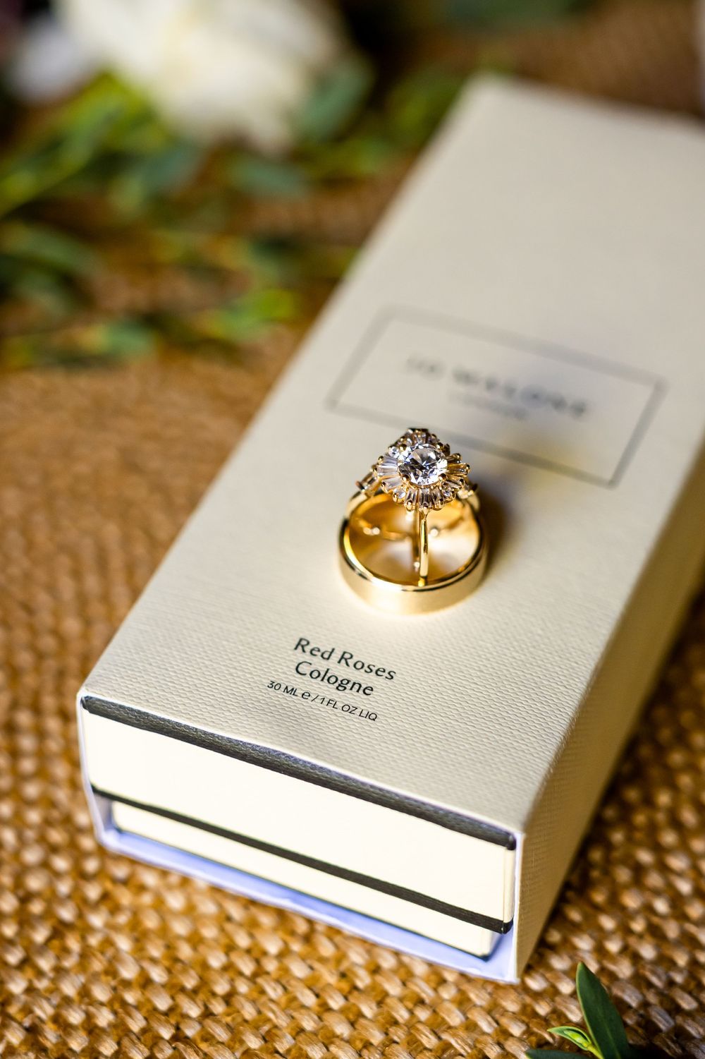 Gold wedding rings displayed on a white book against a textured background.