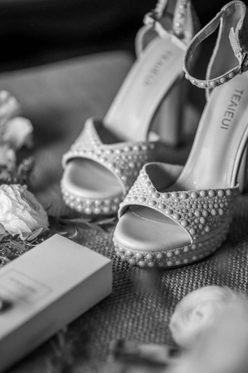 Elegant white bridal shoes adorned with pearl details and crystals.
