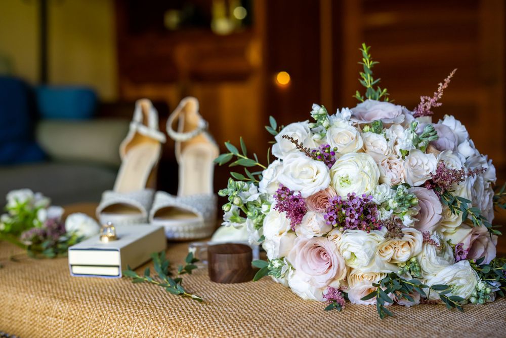 Romantic pastel floral arrangements with roses and greenery displayed at a wedding.