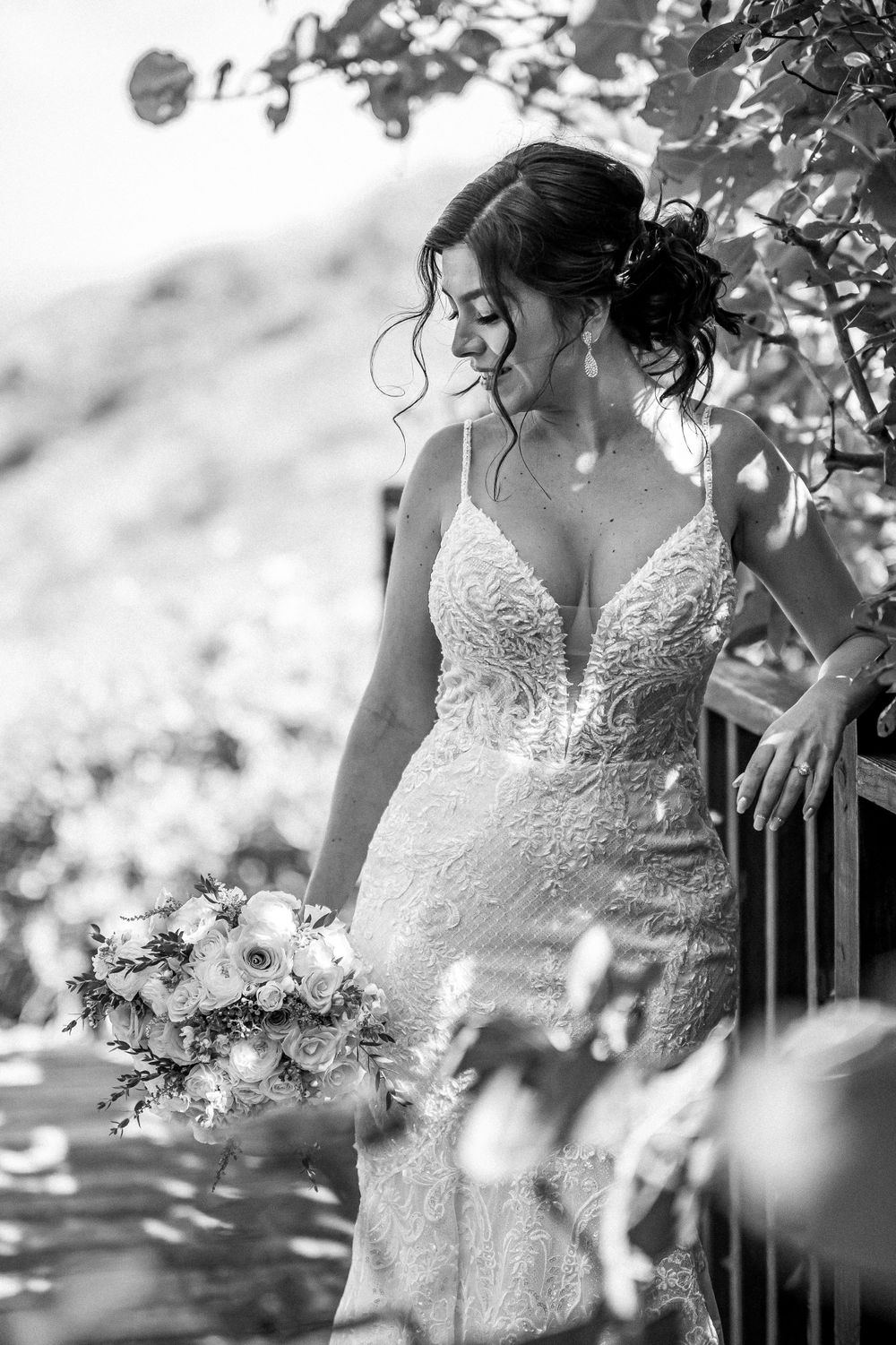 Artistic black and white photo of a lace wedding dress in natural light.