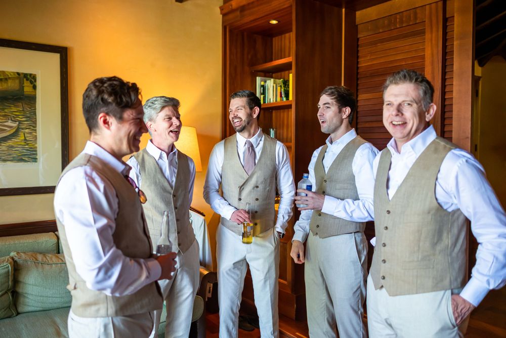 Group of groomsmen in beige vests gather before the wedding ceremony.