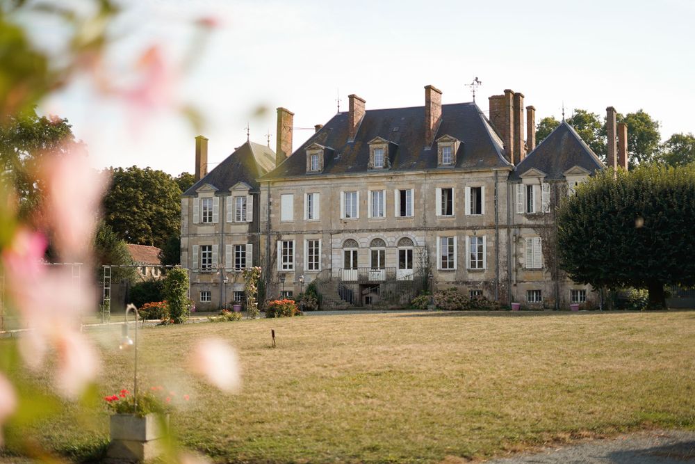 Stately French chateau with symmetrical architecture viewed across a manicured lawn.