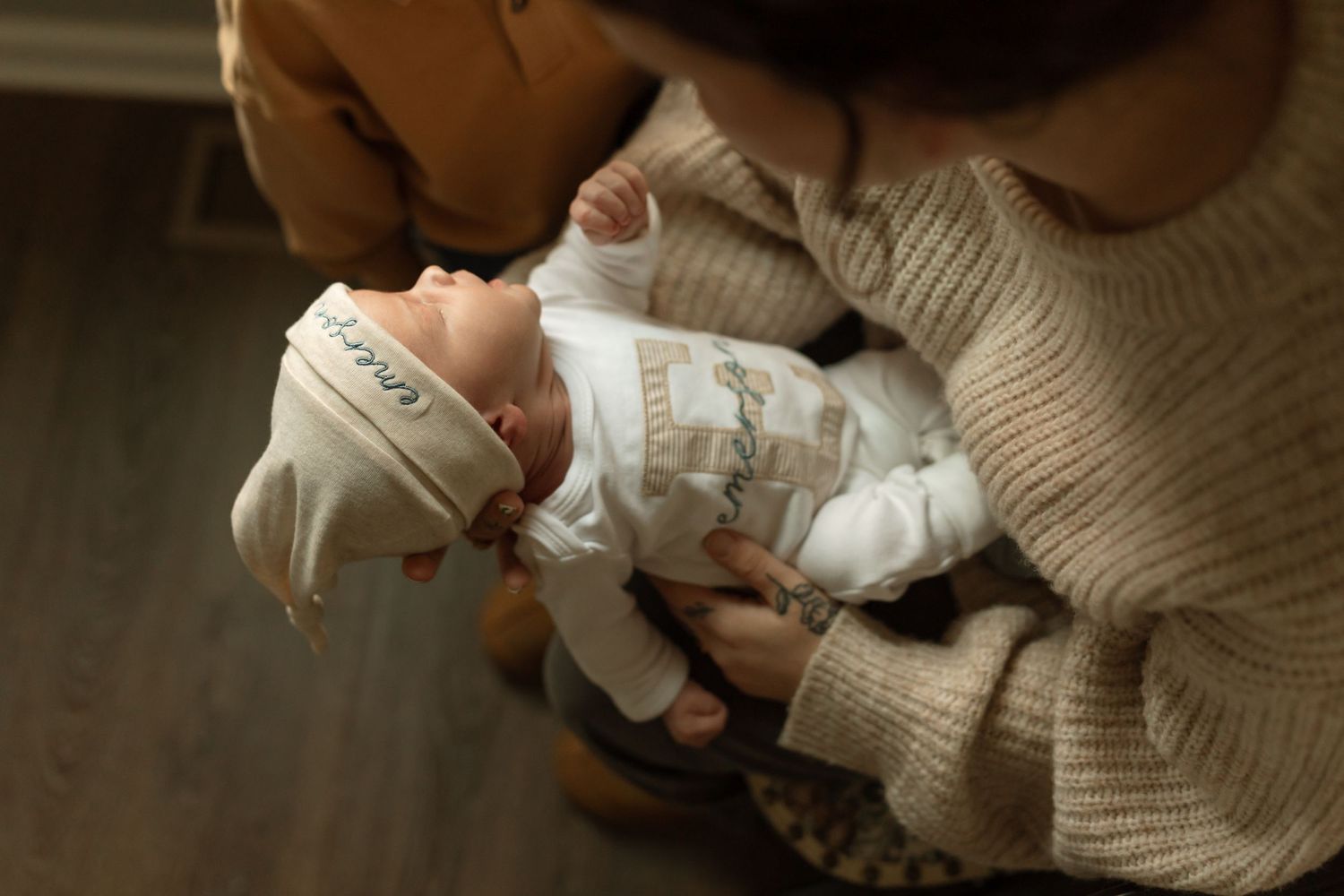 Lifestyle photography series capturing tender moments with newborn in neutral tones.