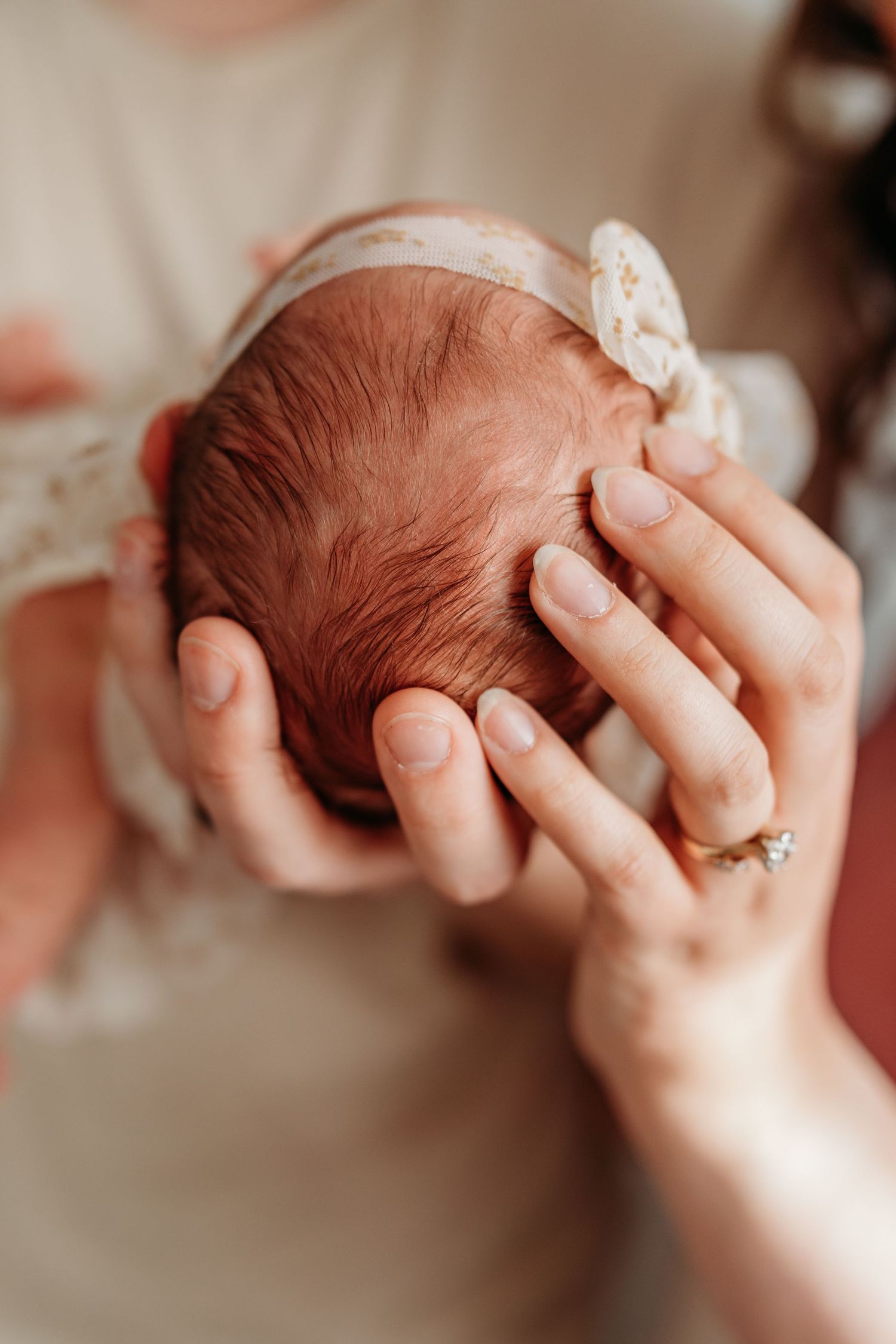 Close-up newborn photography with gentle hands and natural lighting details.