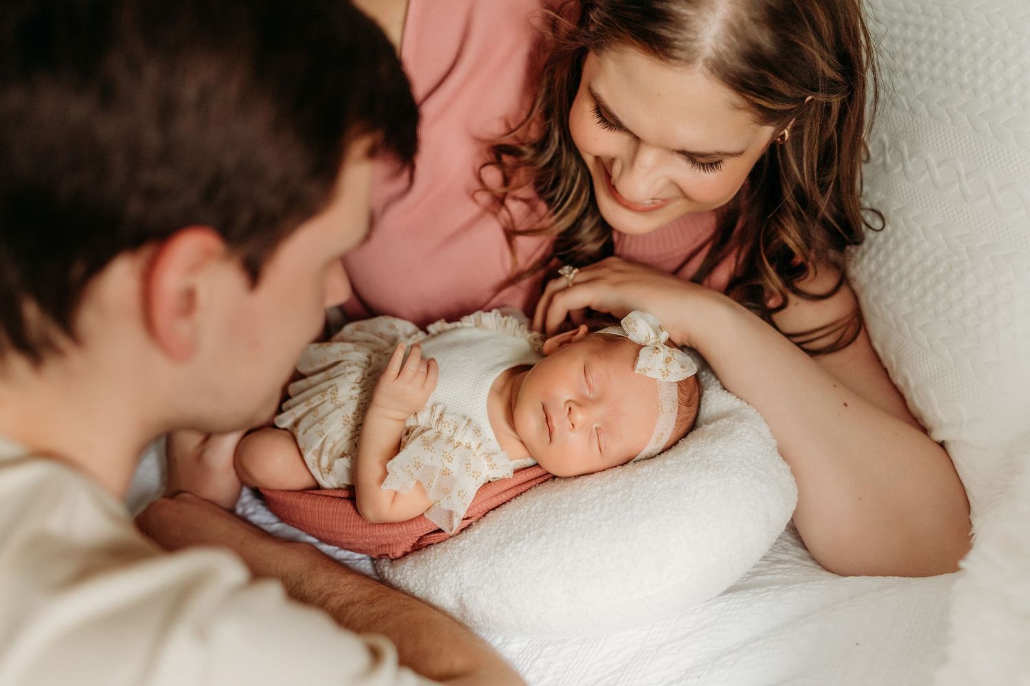 A touching lifestyle newborn photography session at home shows intimate family bonding moments.