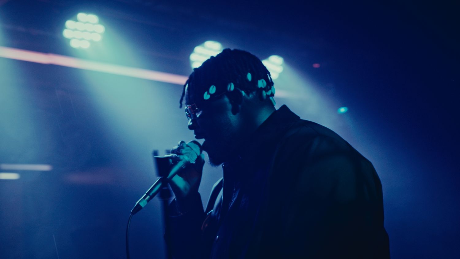 Photograph of an artist singing on stage