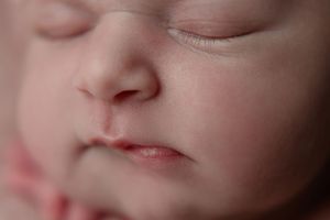Close-up macro shot of a sleeping newborn's face showing delicate features.