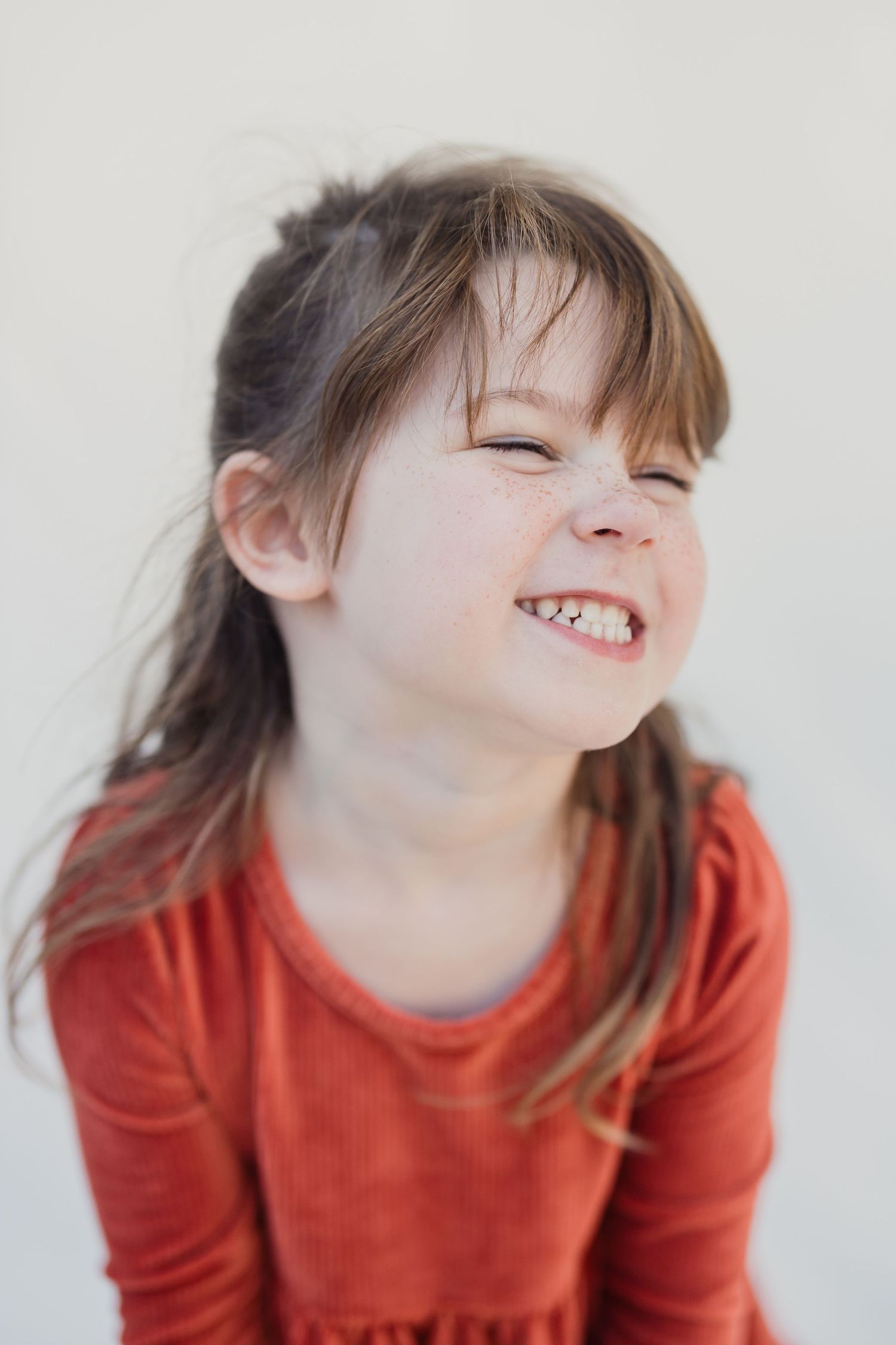 Black and white portrait of a smiling child wearing a Marvel t-shirt.