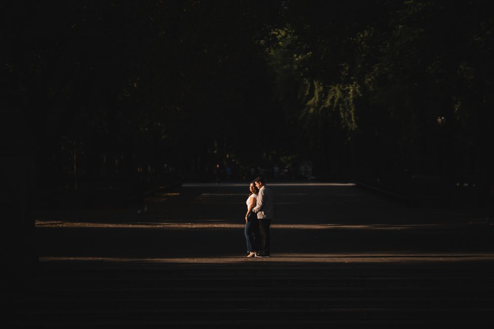 Silhouetted figures sit on stone steps against a dark background.