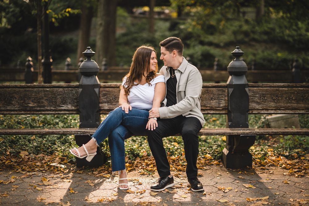 Couple shares intimate moments on stone steps surrounded by autumn foliage.
