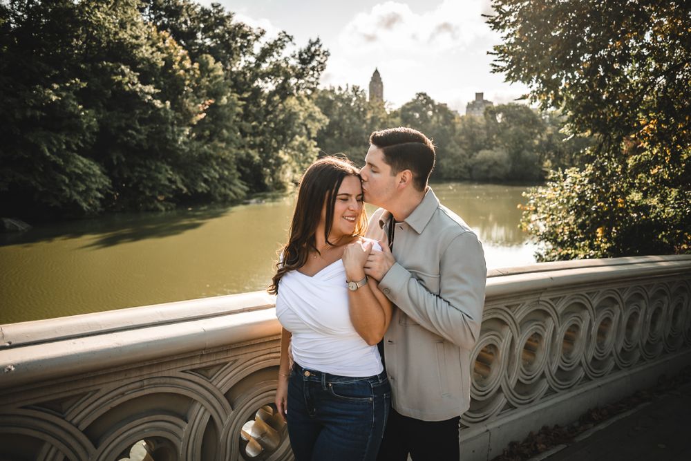 Romantic moment captured on stone balustrade during golden hour.