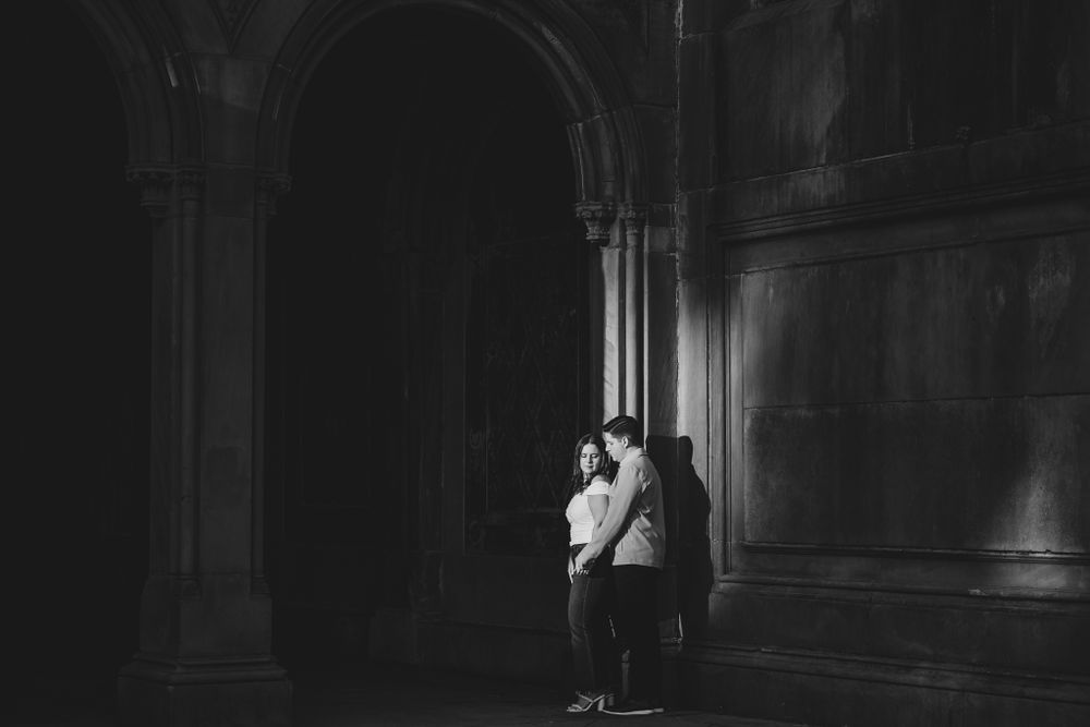 Dark architectural corridor with dramatic lighting and arched details.