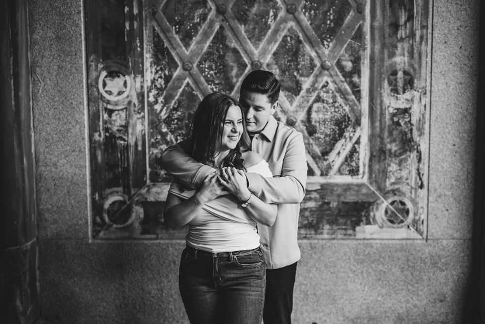 Black and white portrait of couple by ornate architectural details.