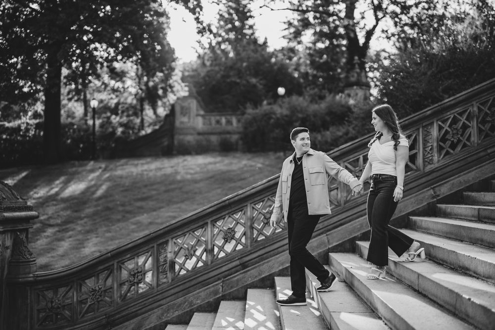 Silhouettes of a couple walking down decorative stone steps at sunset.