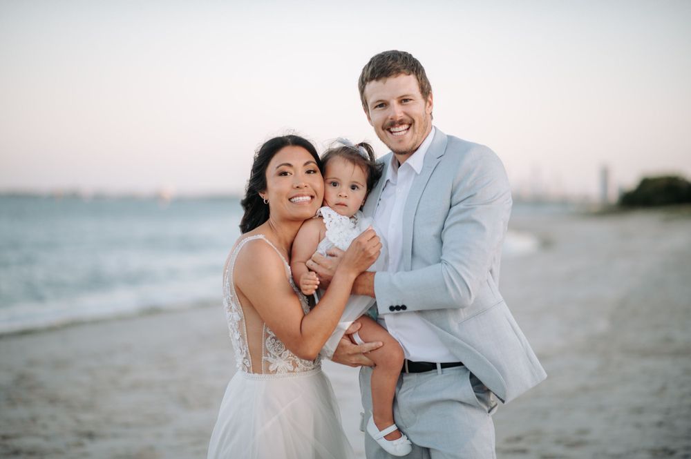 A joyful family moment captured on a beach during sunset.