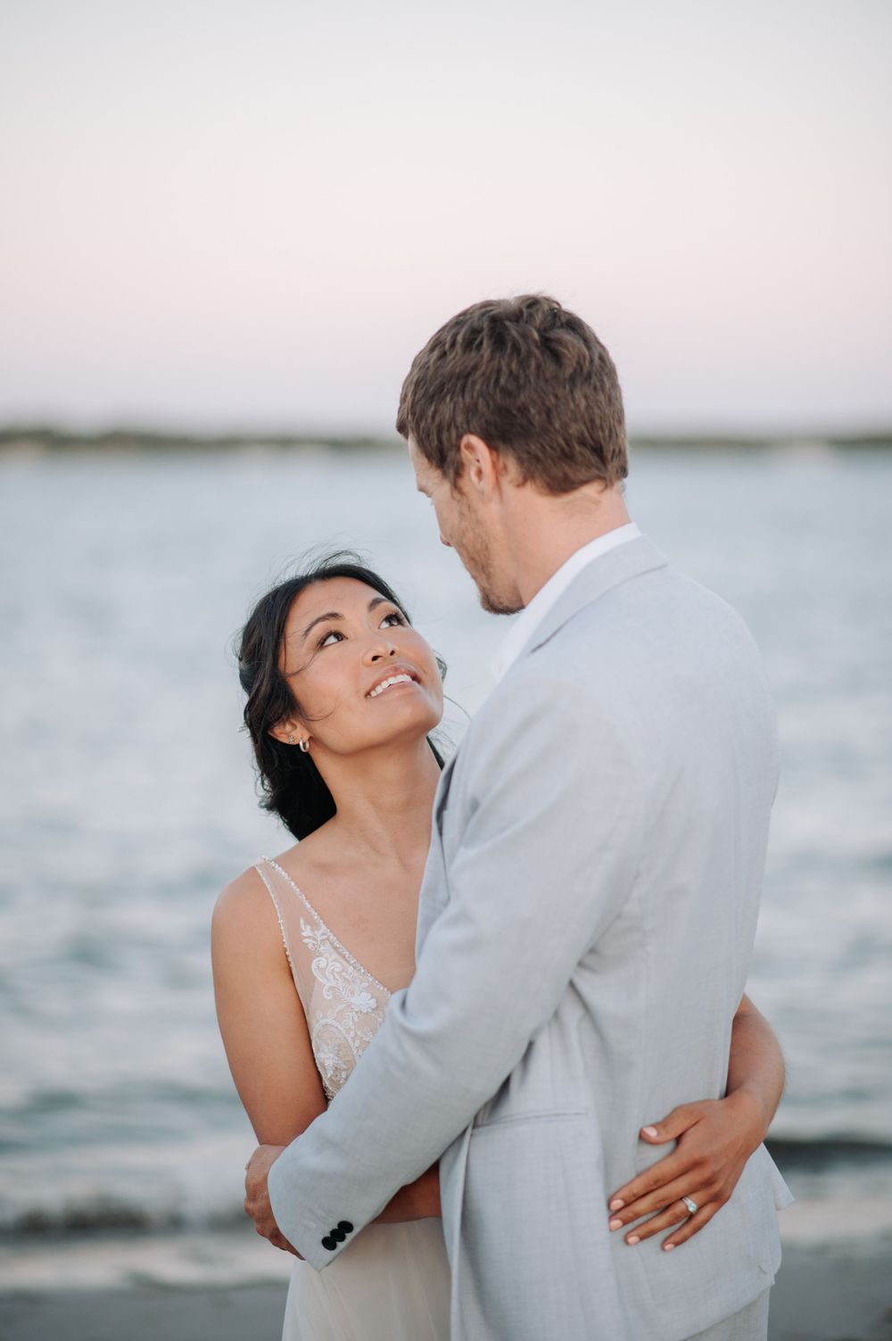 A romantic beachside moment between newlyweds at sunset.