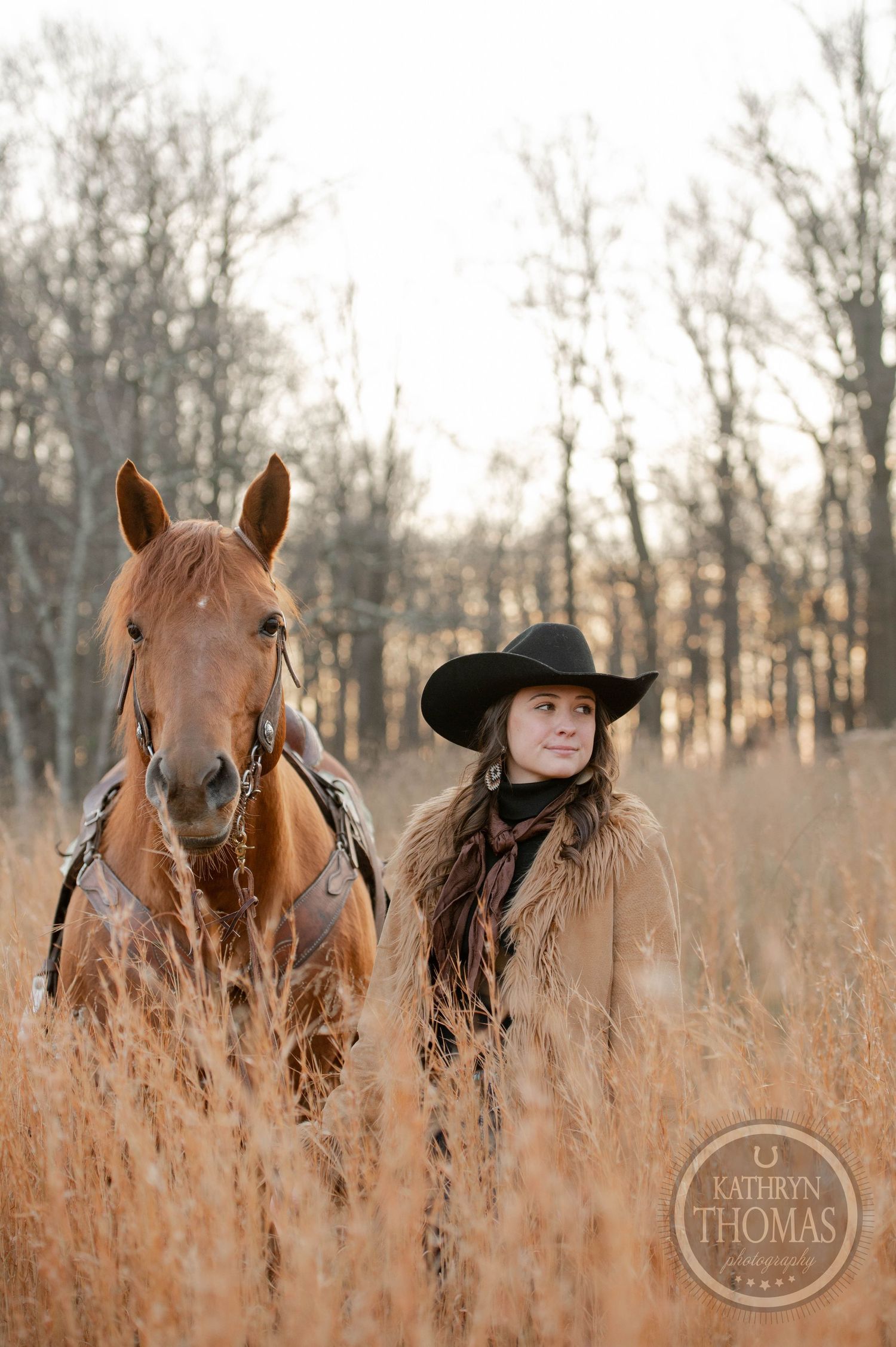 A western portrait of a horse and rider surrounded by tall autumn grass at sunset.