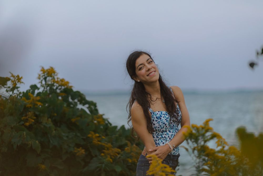 She poses for a portrait amongst yellow flowers at Lake Ontario, in Kingston, ON, CA.