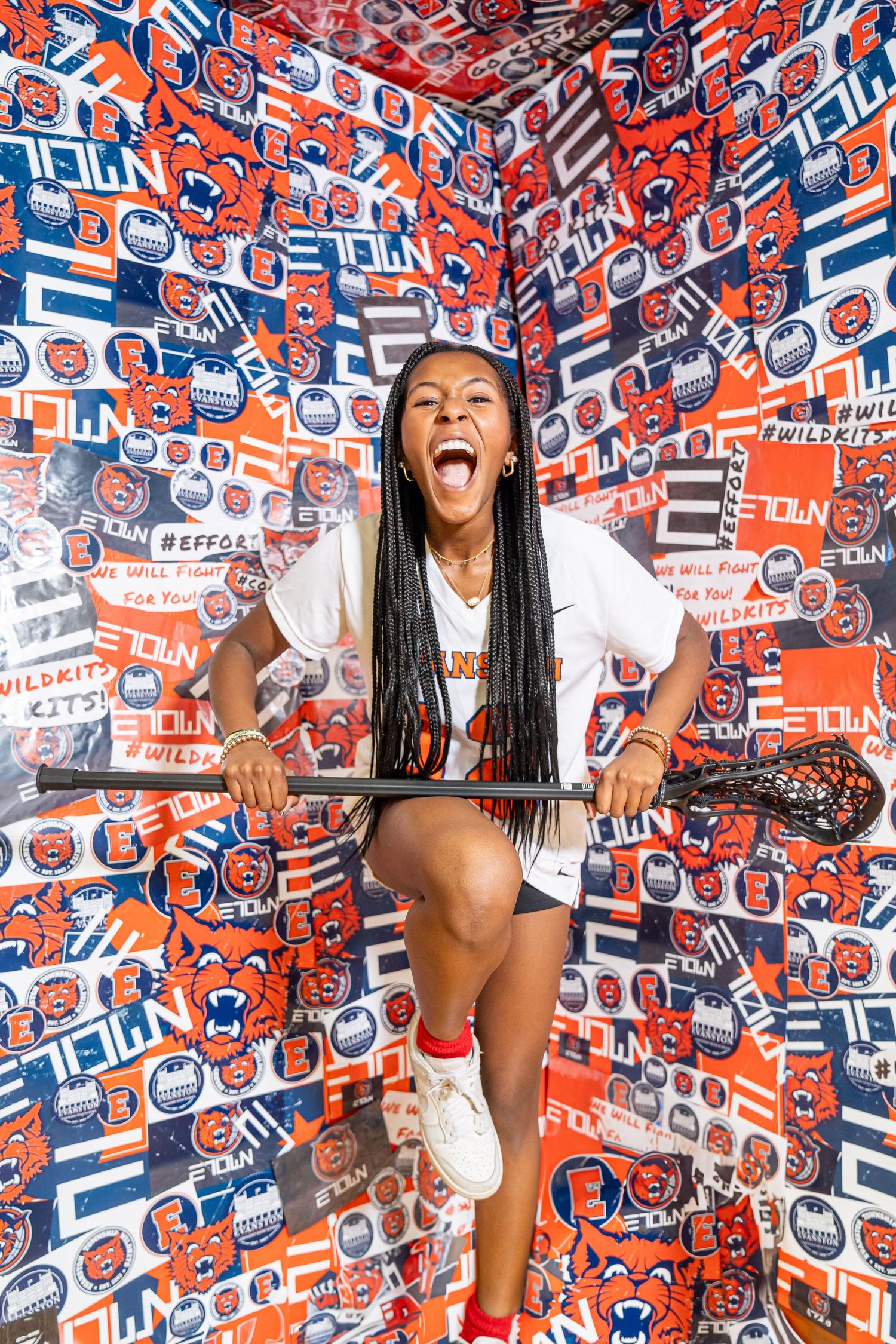Energetic athlete poses against vibrant orange and blue sports-themed wallpaper backdrop with University of Illinois branding.