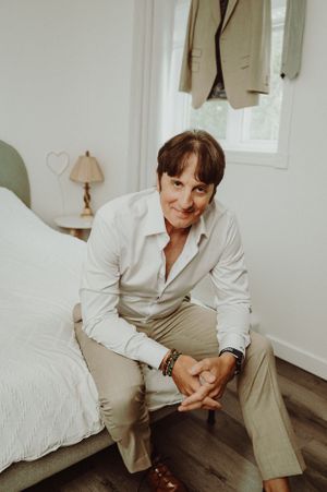 A pre-wedding preparation scene in a bright white room with formal attire.