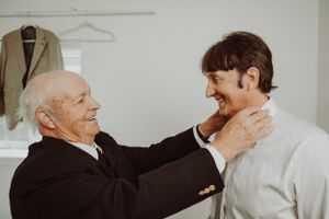 An emotional wedding day moment captured between two people in a bright indoor setting.