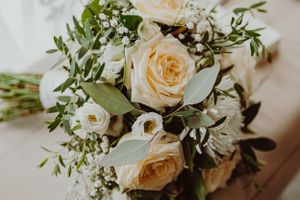 A romantic wedding bouquet featuring peach roses and delicate white flowers with greenery.