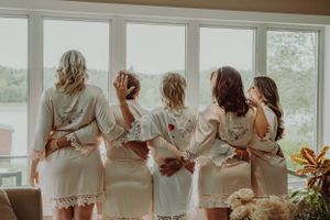 A group wearing matching white robes stands by a window looking out at a scenic view.