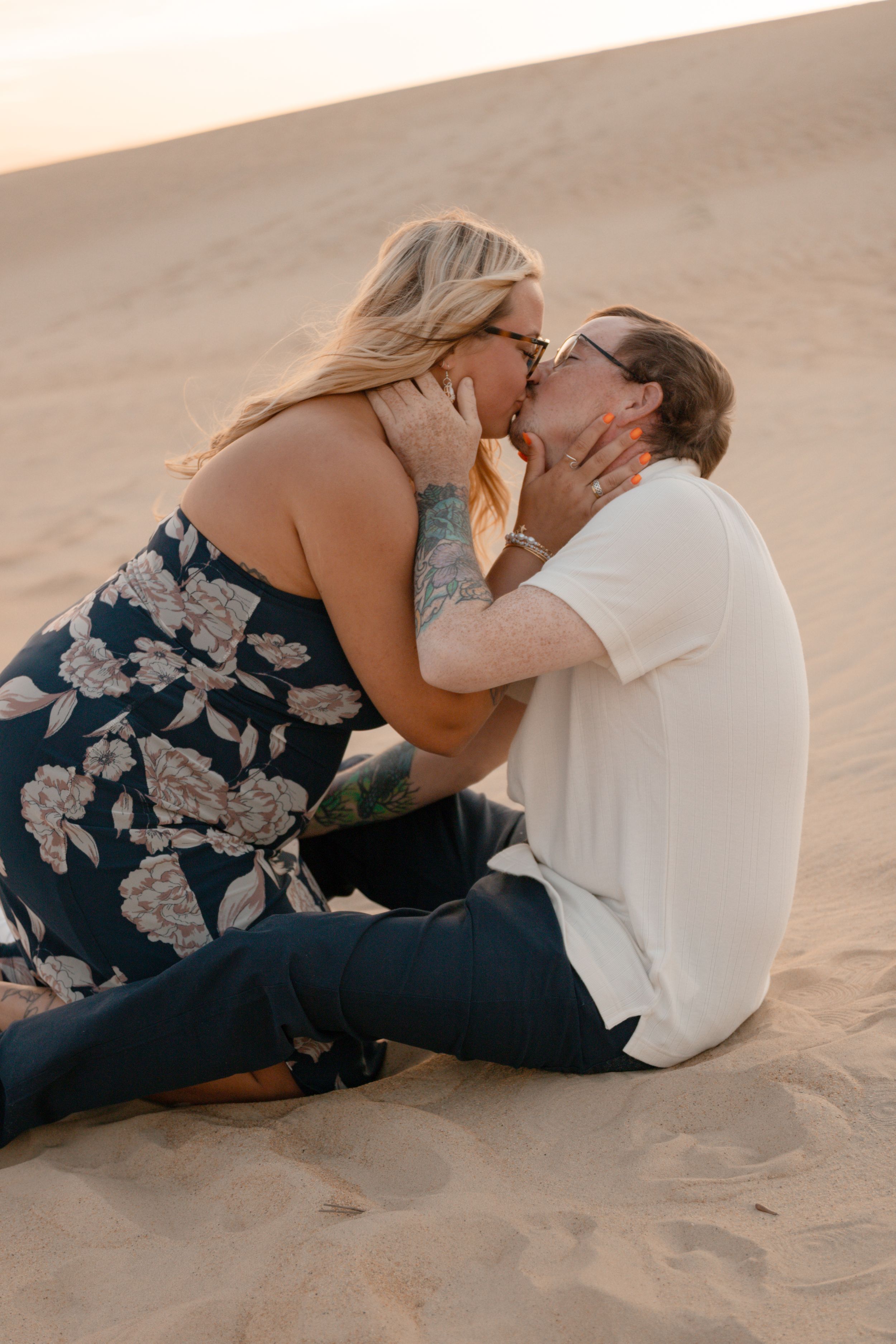 A couple embraces intimately on a sandy beach, creating a series of romantic poses in a flowing sequence.