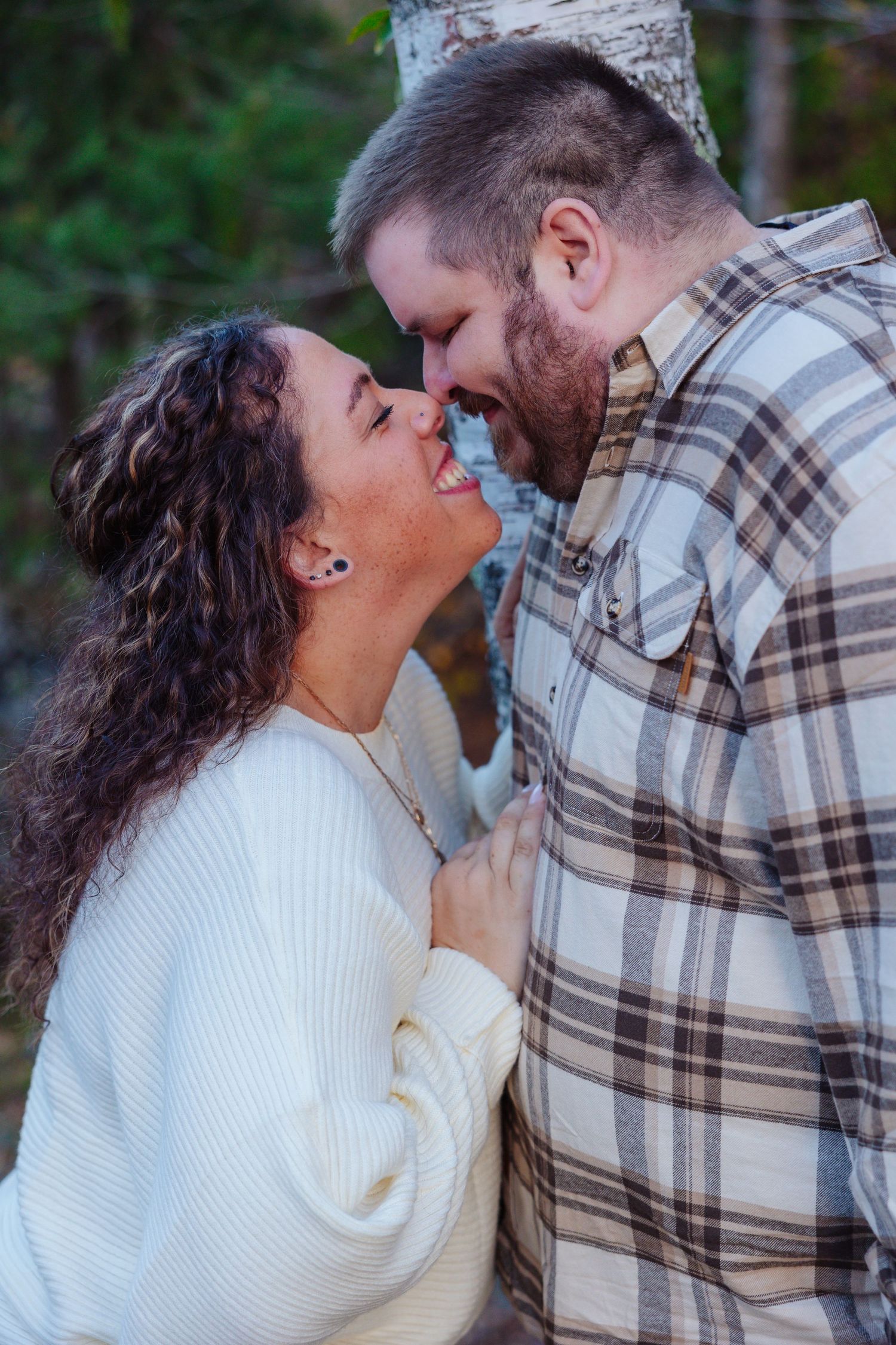 A couple shares a romantic kiss outdoors while wearing cozy winter clothing. Esko MN