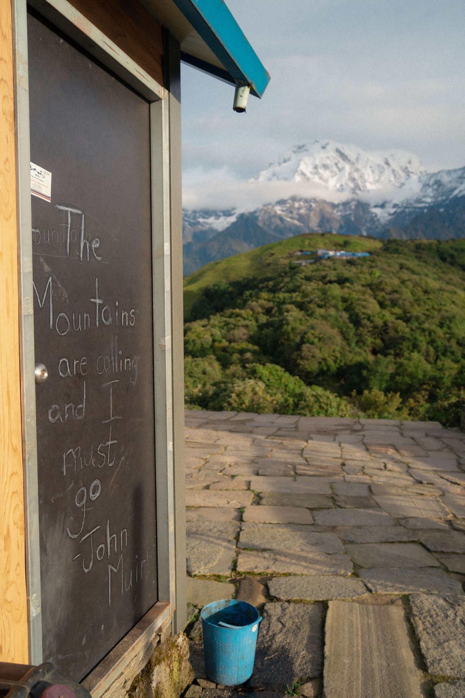 Chalkboard panels mounted on wooden posts frame distant mountain views.