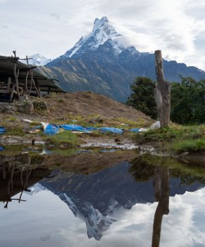Mountain peaks reflect perfectly in a still pond creating a mirror image.