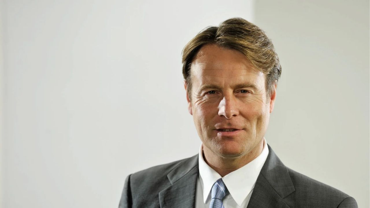 A white man telling a story with his eyes on grey suit