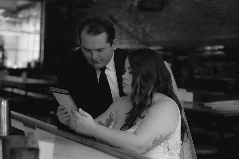 A couple shares an intimate moment while reading together at a wedding reception.