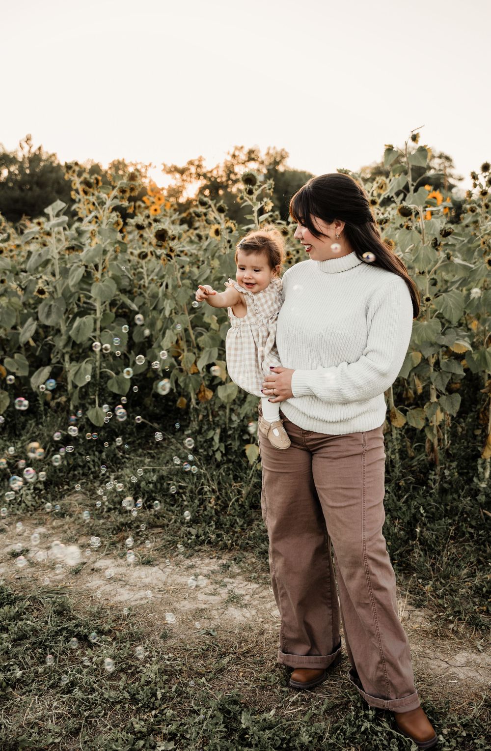 Lifestyle family photography session in a rustic sunflower field setting.